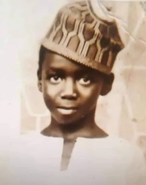 AbdulRahman AbdulRazaq as a boy, in a cap